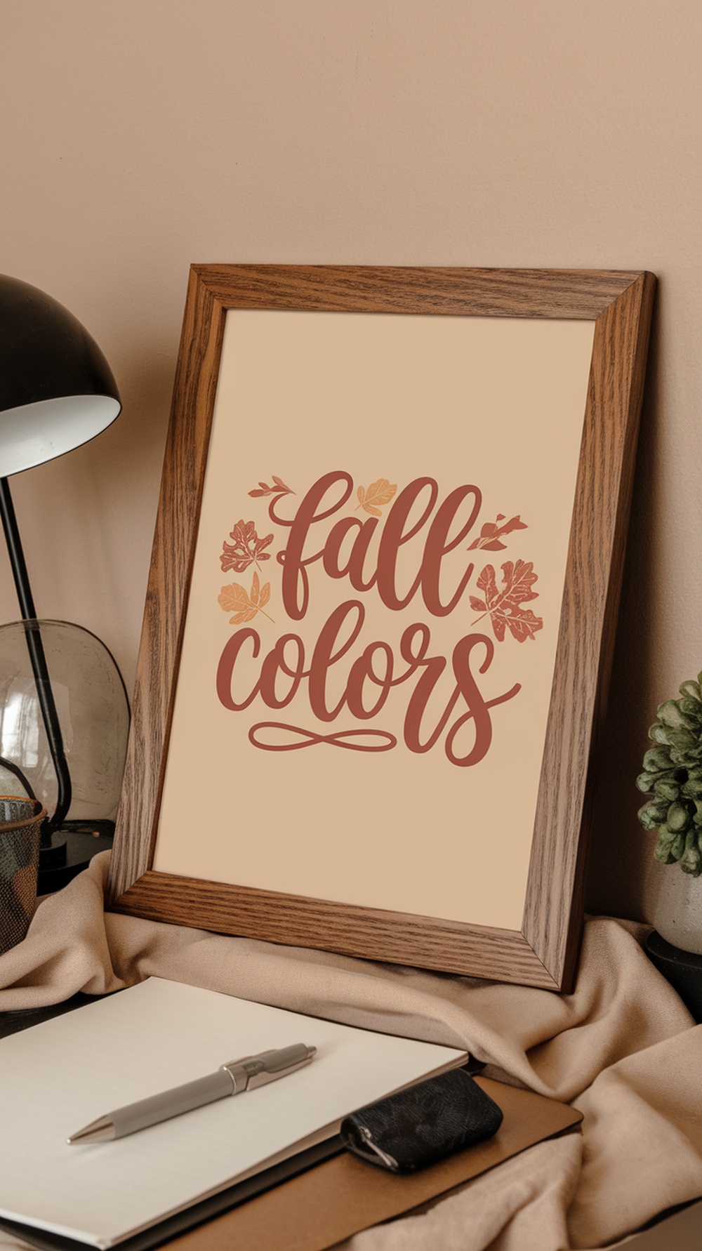 A collection of framed seasonal quote prints displayed on a wall, with a small green arrangement on a desk.