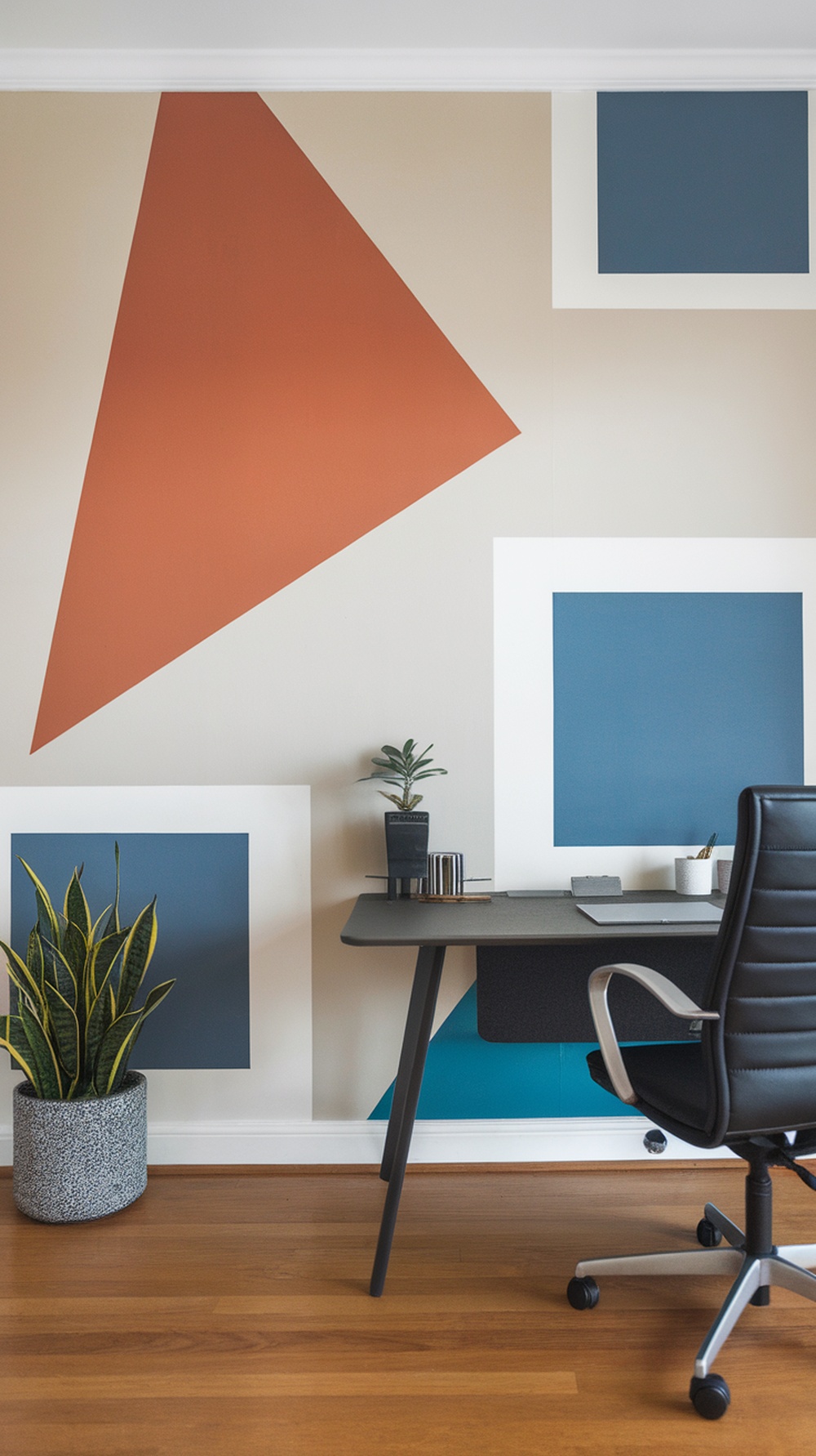 A modern home office with geometric patterned wallpaper featuring triangles and squares in various colors.